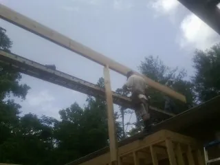 Carpenter setting a ridge beam over a new addition frame — Ice Dam Removal by Roofing Brothers in Taopi