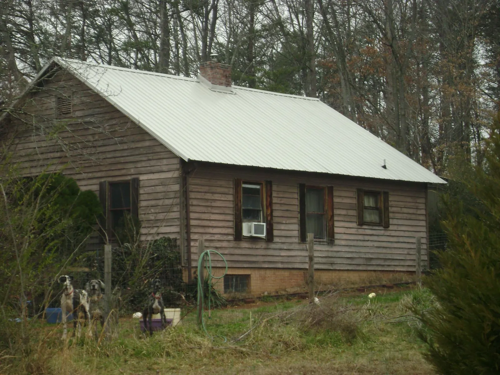 White metal roof on an old wood sided farmhouse, from a Metal Roof Installation job in Taopi